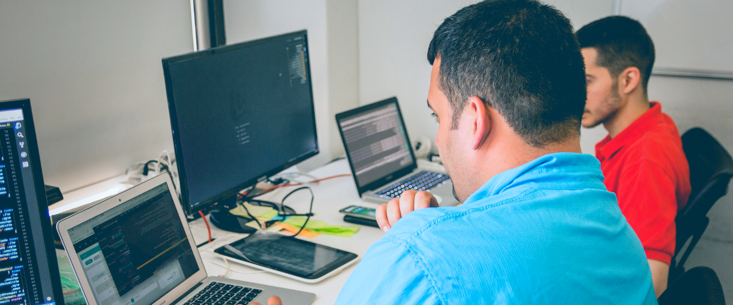 Two males use computers.